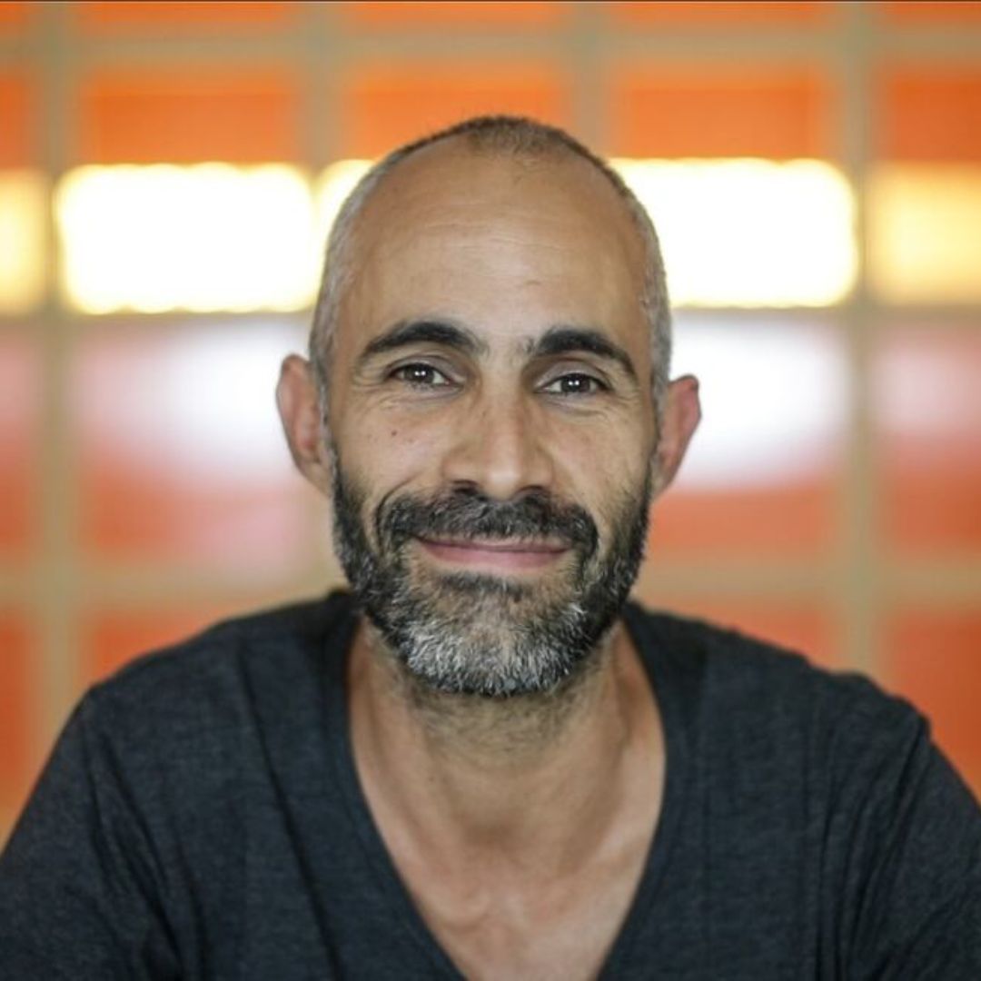 Lleva más de 25 años acompañando a personas a través del yoga. Es activista enfocado en la justicia social y en devolverle al yoga su raíz comunitaria y accesible.